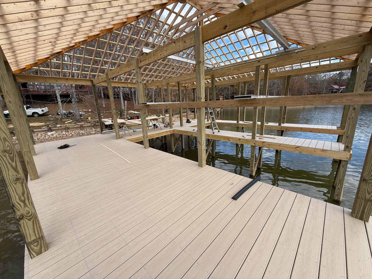 Dock decking and roof framing in progress over the water