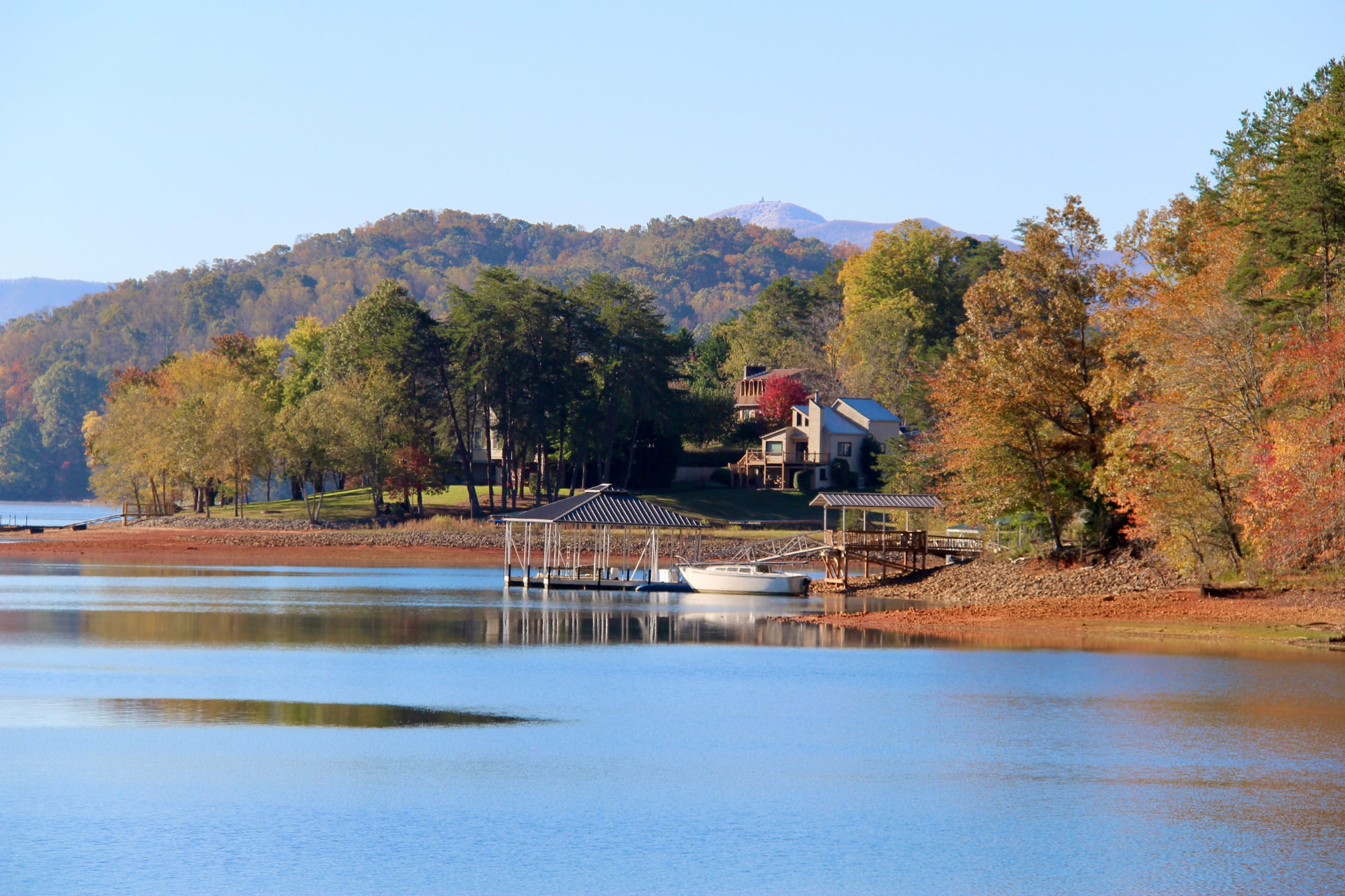 Waterfront lake home with a private boat dock at golden hour