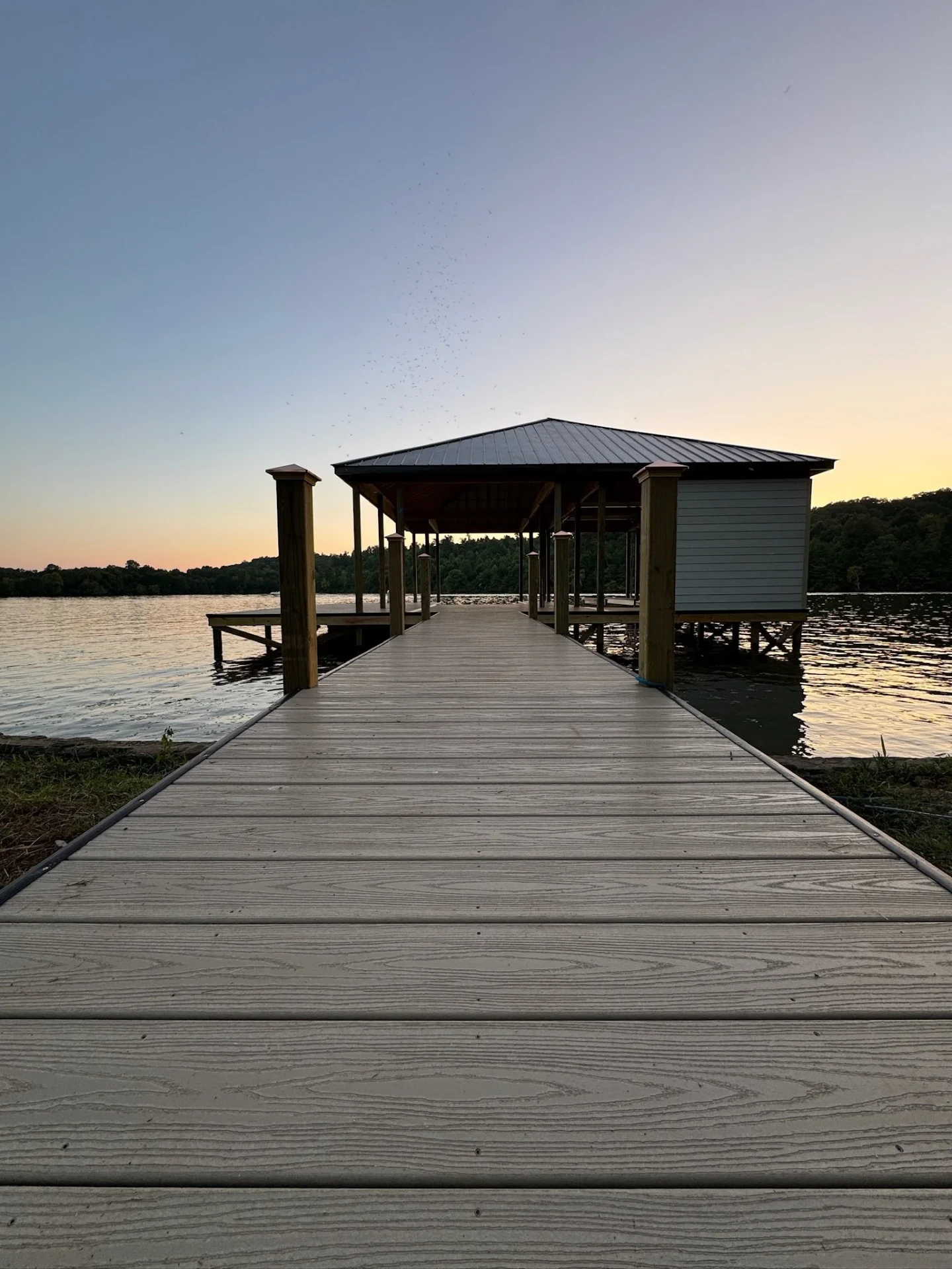 Covered dock pavilion with walkway on an Alabama lake at sunset